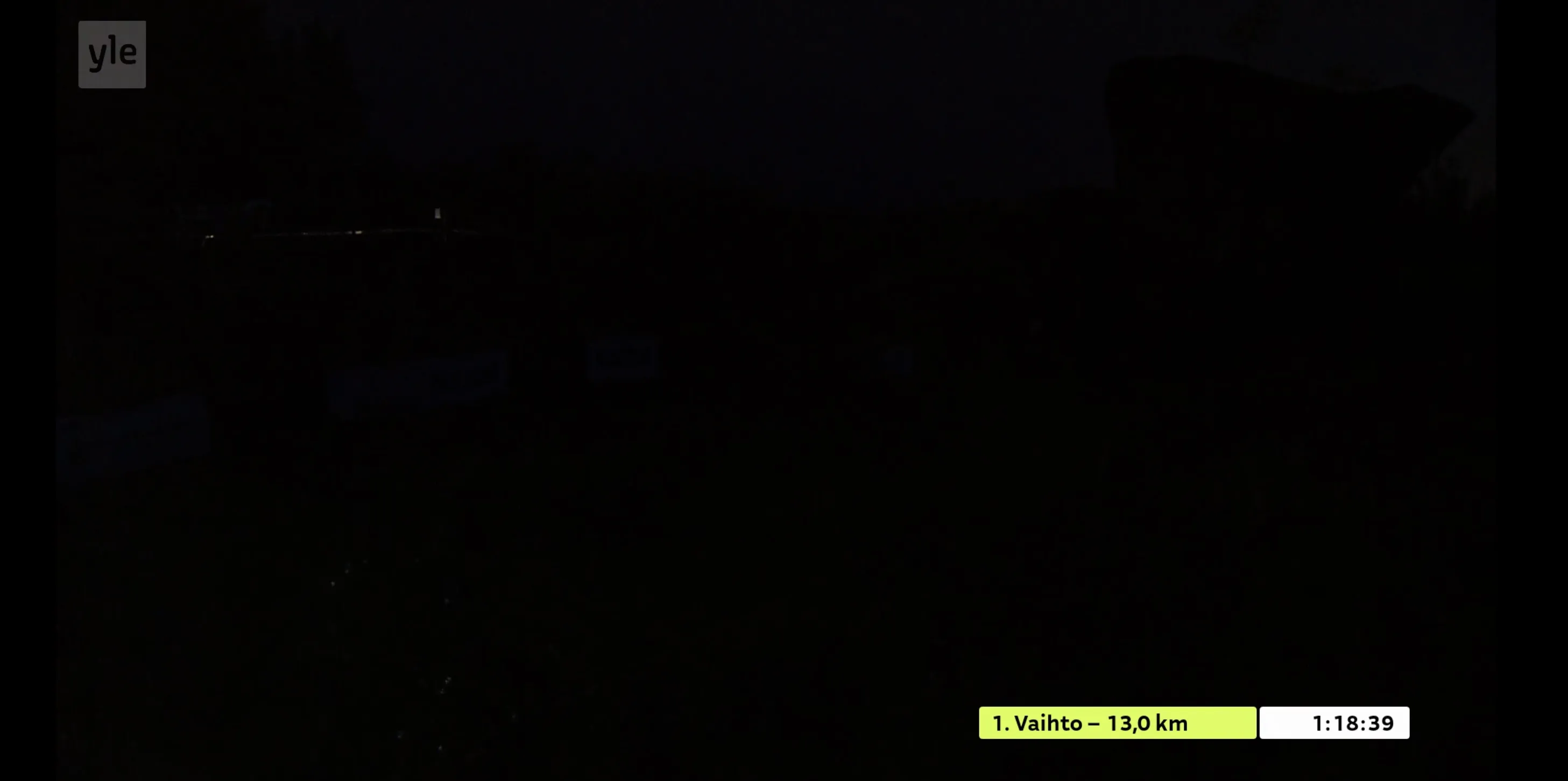 A darkness of the night with pretty much nothing visible but an on-screen graphic about first leg finish and time 1:18:39.